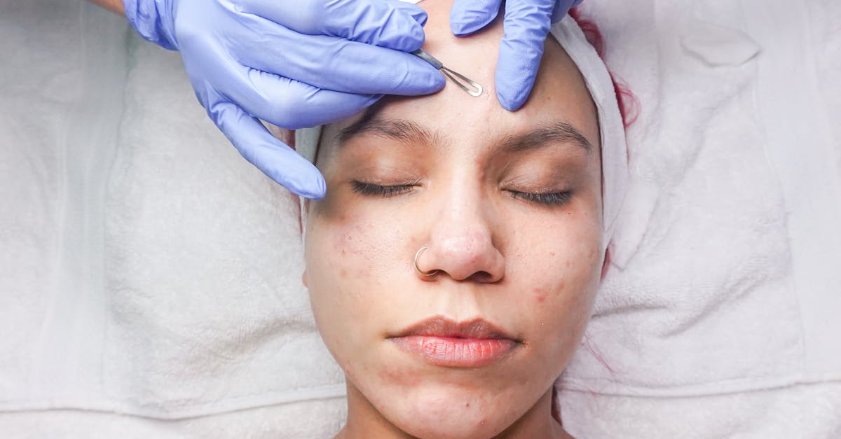 Woman undergoing professional facial treatment with eyes closed and gloves.